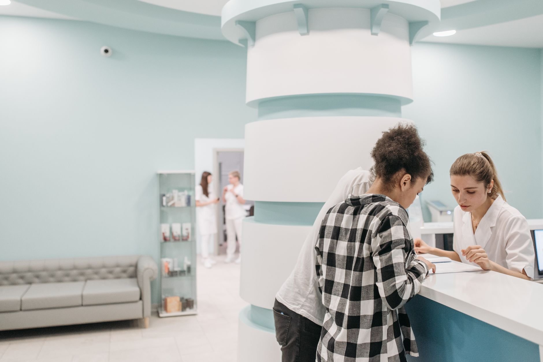 Healthcare professionals assisting patients at a clinic reception desk
